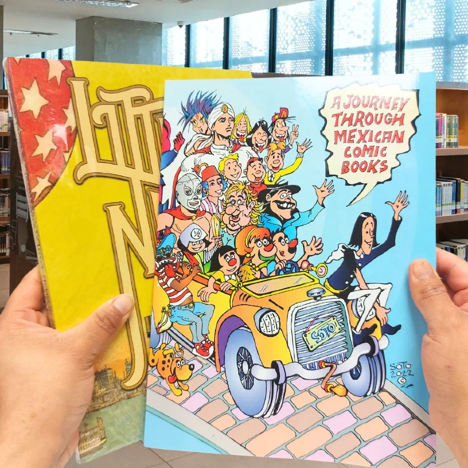 Two large-format books held up in a library, one a history of Mexican comic books